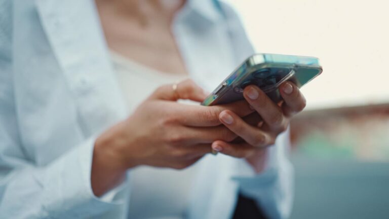 スマートフォンを操作する女性の手元のクローズアップ