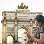 ミュンヘンの凱旋門「ジーゲストーア」を背景に観光マップを持つ女性旅行者