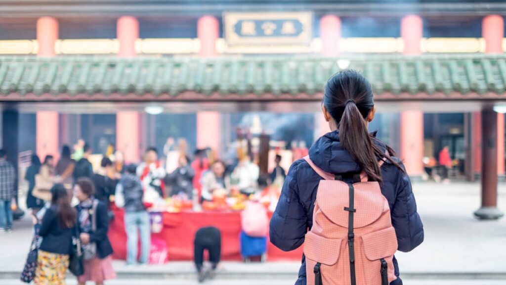 香港の寺院を訪れるバックパック姿の女性観光客