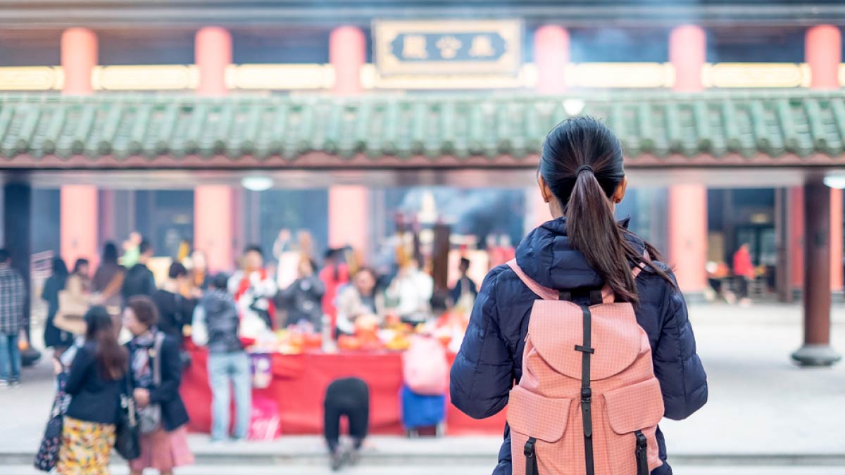 香港の寺院を訪れるバックパック姿の女性観光客