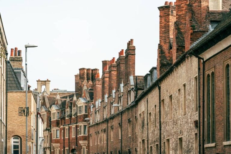 ケンブリッジの歴史あるレンガ造りの建物が並ぶ街並み。赤い煙突と石造りの壁が特徴的な景観。