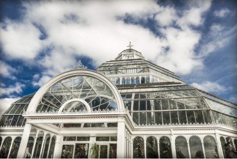 リバプールのセフトン・パーク内にあるパームハウス。歴史あるガラス温室が青空の下に輝く外観