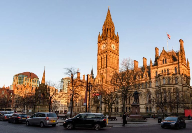 夕日に照らされるマンチェスター市庁舎とアルバート広場の街並み