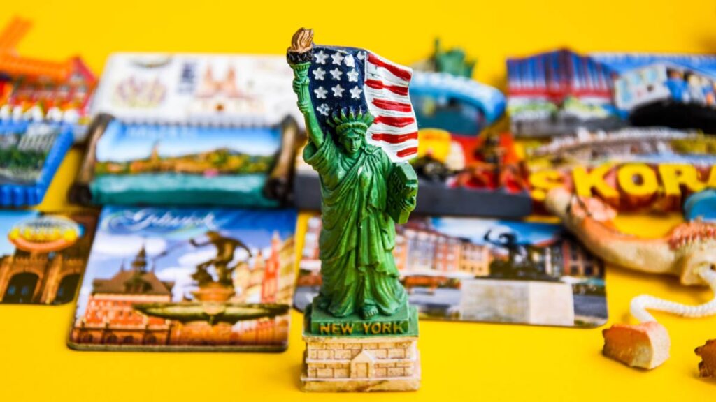 アメリカ・ニューヨーク限定の自由の女神フィギュア型マグネットを中心に、世界各国の観光マグネットが並べられた様子。