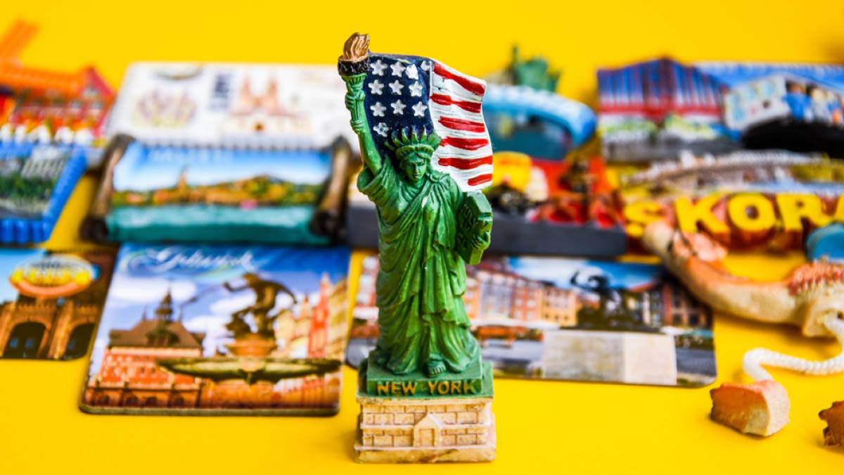 アメリカ・ニューヨーク限定の自由の女神フィギュア型マグネットを中心に、世界各国の観光マグネットが並べられた様子。