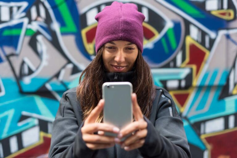 メルボルンのホイザー・レーンでカラフルなストリートアートを背景に写真を撮る観光客