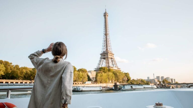セーヌ川越しに見えるエッフェル塔とその景色を楽しむ女性の後ろ姿