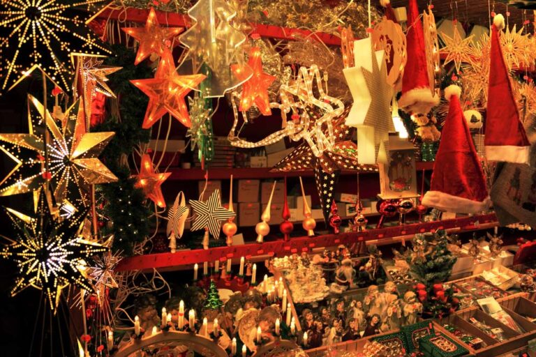 アウクスブルクのクリスマスマーケットで並ぶ星形のイルミネーションとサンタ帽の飾り
