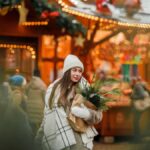 クリスマスマーケットで買い物を楽しむ冬服の女性