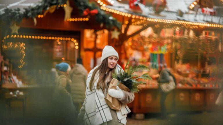 クリスマスマーケットで買い物を楽しむ冬服の女性