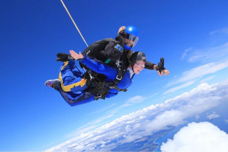 青空と雲海を背景に、インストラクターと一緒にスカイダイビングを楽しむ様子。ウィットサンデー諸島の絶景を上空から体感できる迫力あるアクティビティの瞬間