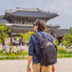 ソウルの景福宮を観光するバックパックを背負った男性旅行者