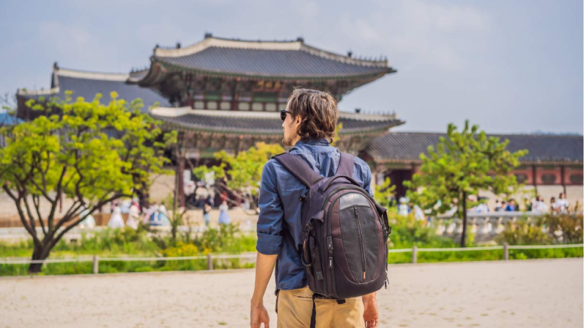 ソウルの景福宮を観光するバックパックを背負った男性旅行者