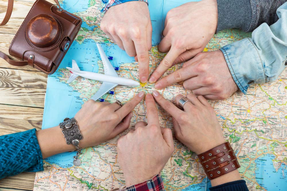 計画を立てる人がヨーロッパの地図のパリを指している様子