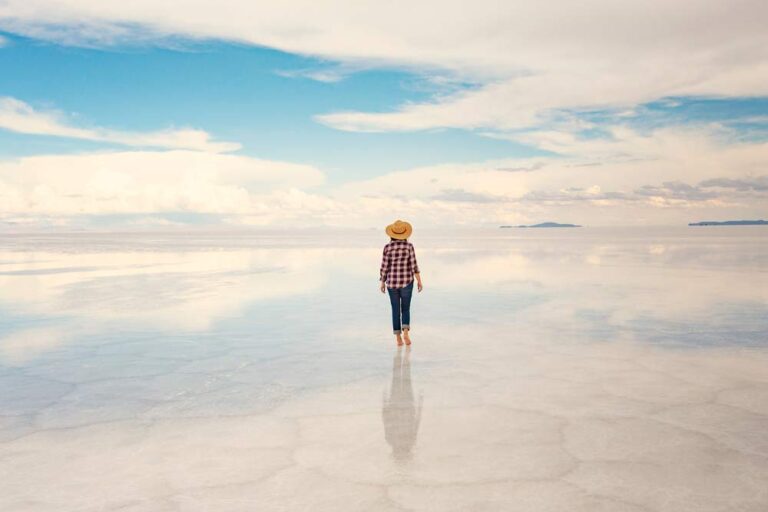 ボリビア・ウユニ塩湖を歩く旅行者。空と大地が一体化した“天空の鏡”のような絶景が広がる