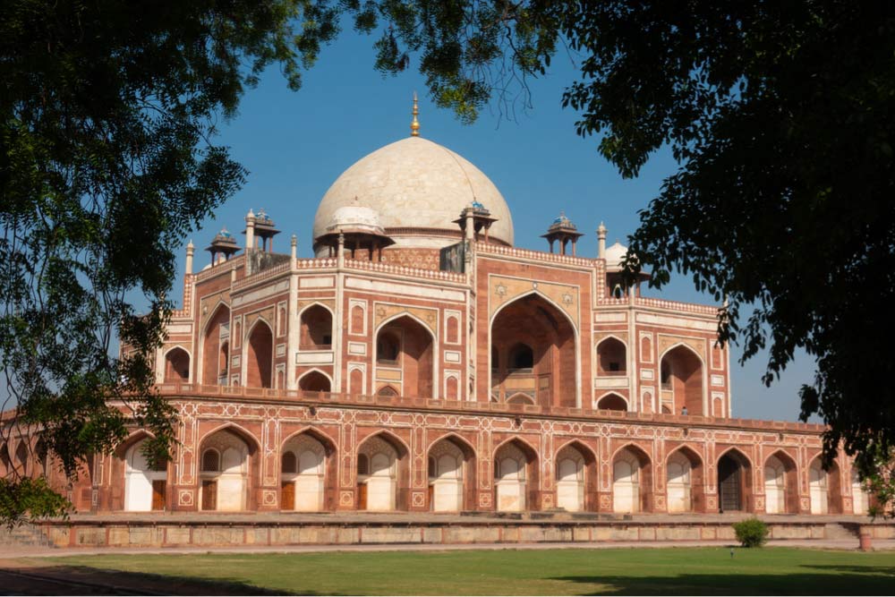 デリーのフマユーン廟を囲む青空と緑。ムガル建築の美しさが映えるインドの春の風景。
