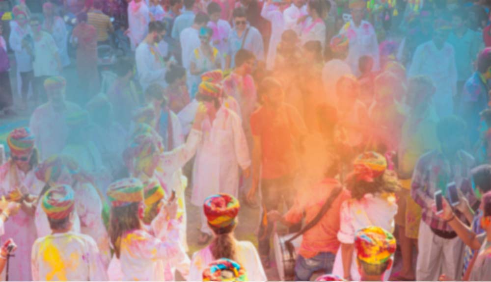 3月のインド・ホーリー祭で色粉をかけ合い笑顔を見せる人々。春の訪れを祝うカラフルで賑やかな祭典の様子。