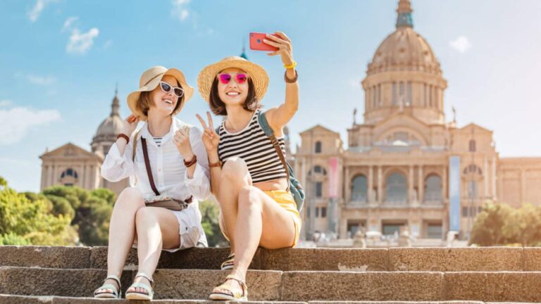 歴史ある建物を背景に、春の陽気の中で記念撮影を楽しむ女性旅行者たち。