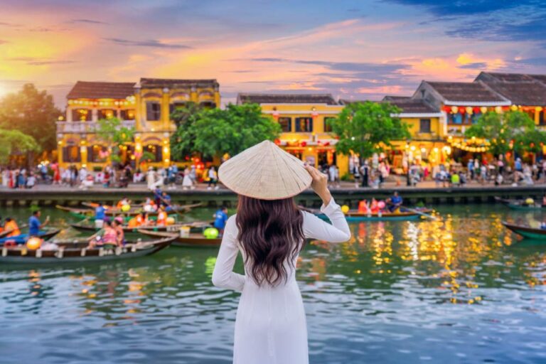 ベトナム・ホイアンの旧市街で、色とりどりのランタンが灯る川辺を眺める女性旅行者