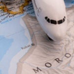 モロッコの地図の上に置かれた飛行機の模型が、旅行やフライトをイメージさせる風景