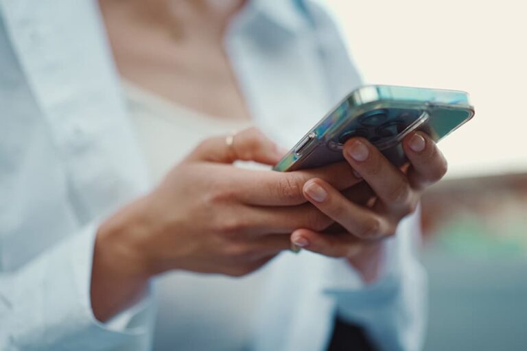 両手でスマートフォンを持ち、eSIMの設定や操作を慎重に確認する女性の手元