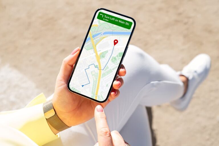 屋外でスマートフォンの地図アプリを開き、ナビ機能を使って目的地までの道のりを確認する様子