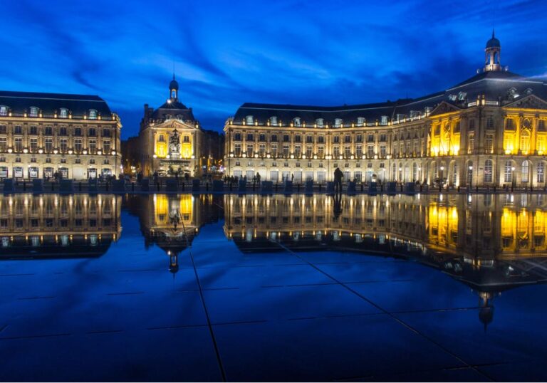 ボルドーのブルス広場で、ミロワール・ダルーに映り込む夜景とライトアップされた建物が美しく広がる風景