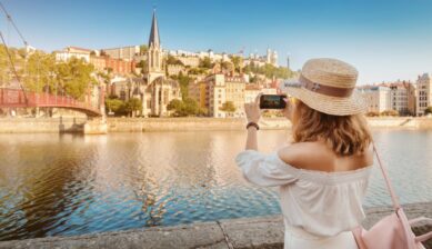 ソーヌ川沿いで旧市街とフルヴィエールの丘を撮影する観光客。リヨン観光を象徴する絶景スポットのひとつ。