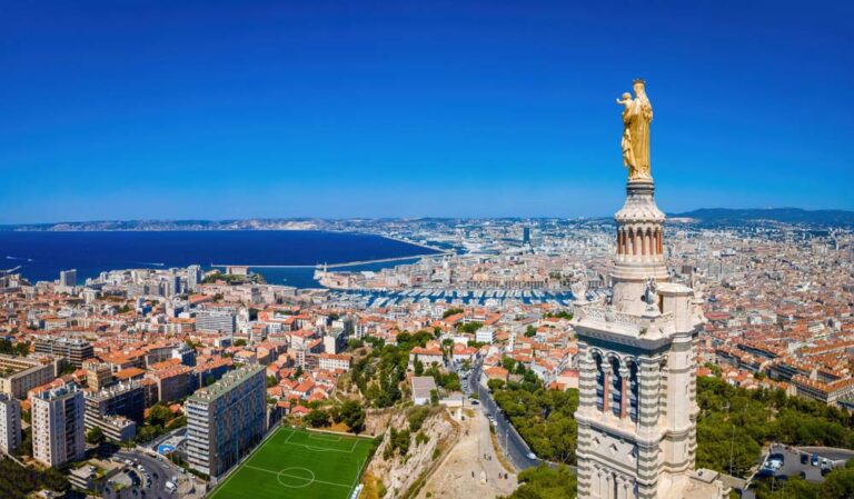 ノートルダム・ド・ラ・ガルド寺院の黄金像越しに、マルセイユ旧港と地中海を一望できるパノラマ風景