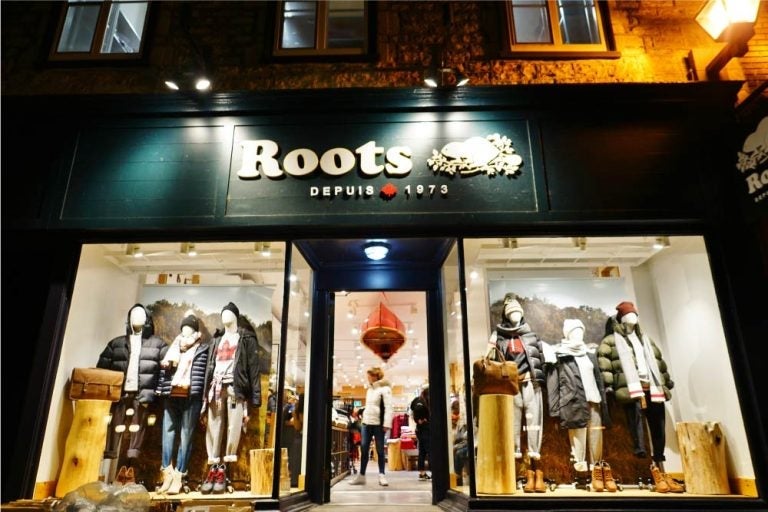 夜に灯りがともるカナダのアパレルブランド「Roots」の店舗外観