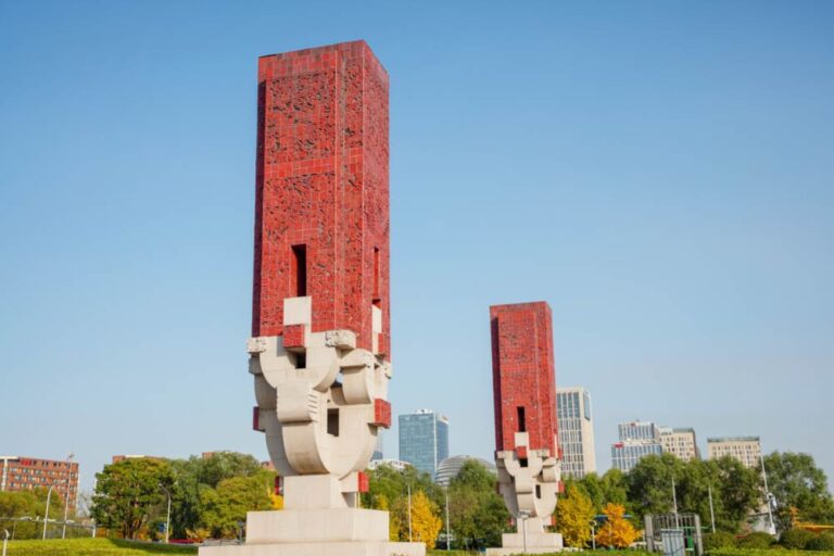 北京オリンピック公園エリアに設置された赤いモニュメント彫刻と都市風景