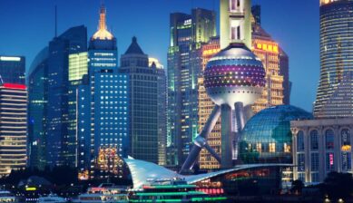 中国・上海の浦東エリアにある東方明珠塔と夜景の高層ビル群