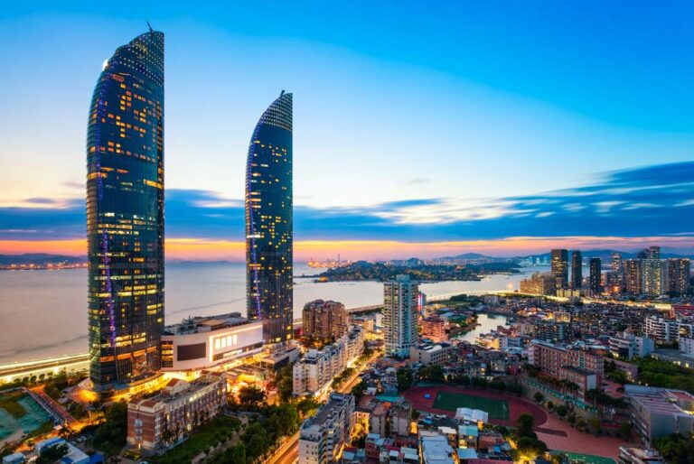 中国・廈門の世茂ツインタワーを望む夕暮れの湾岸都市の夜景