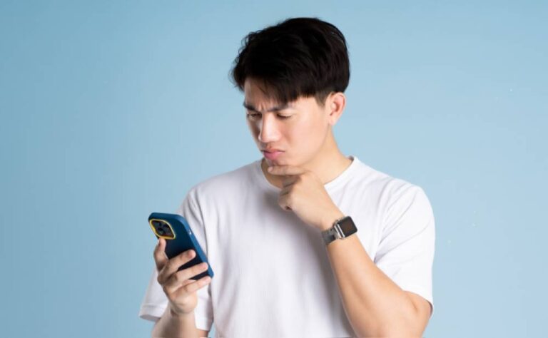 eSIMの通信が繋がらず、スマートフォンの設定を確認している男性