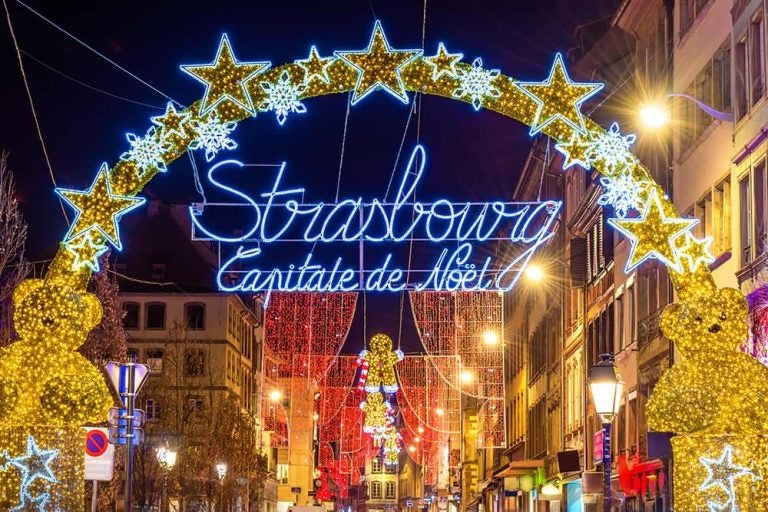 「クリスマスの首都」ストラスブールを象徴する、星やクマの煌びやかなイルミネーションアーチで彩られた夜の街並み