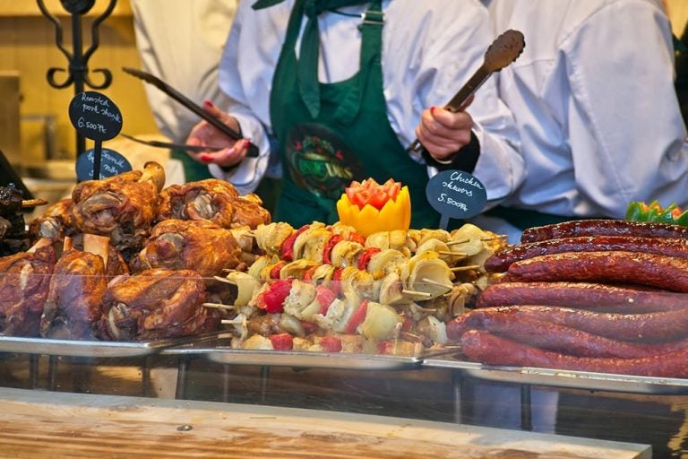 ハンガリーのクリスマスマーケットの屋台に並ぶ、こんがり焼かれた肉や巨大なソーセージなどのボリューム満点で温かい郷土料理