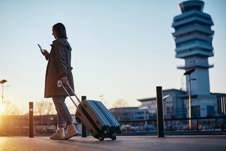 空港でスマホを使う旅行者が、海外でデータローミングを利用して移動中もインターネット接続できるメリットを示した写真
