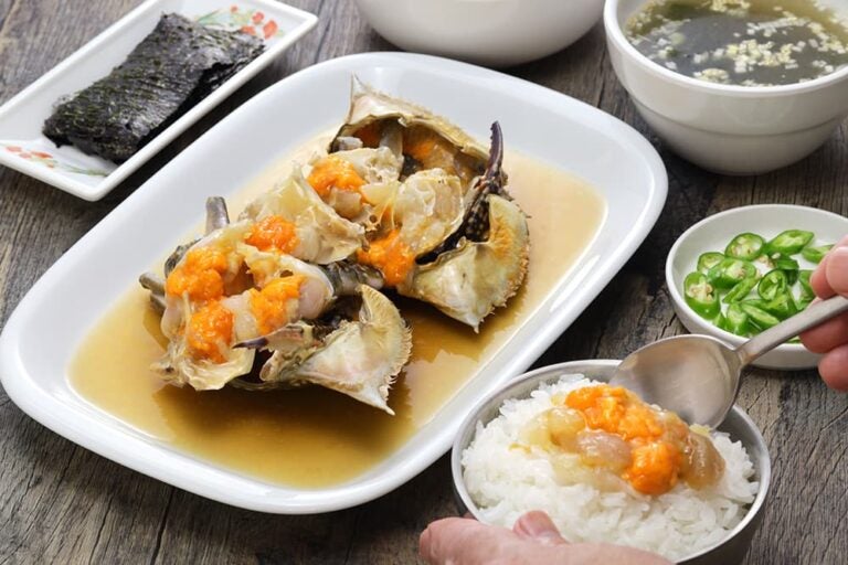 韓国の秋の旬グルメ、カンジャンケジャン（ワタリガニの醤油漬け）をご飯と一緒に楽しむ様子