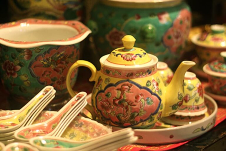 シンガポールのプラナカン文化を象徴する、鮮やかな花柄の陶器ティーポットとカップのセット
