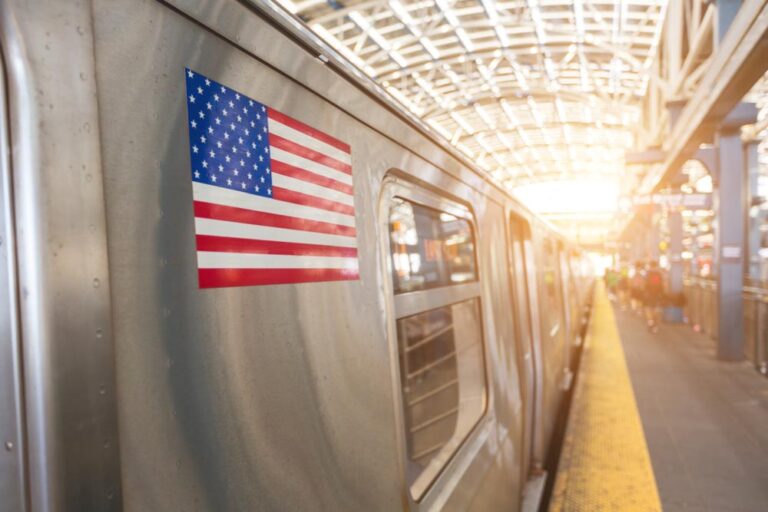 アメリカ国旗のステッカーが貼られた地下鉄車両と駅のホーム。