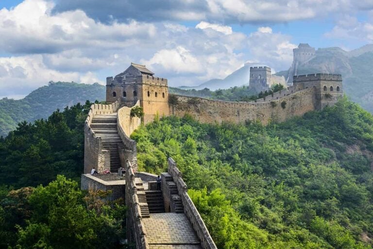 緑深い山々の稜線に沿って続く万里の長城と見張り台の壮大な眺め