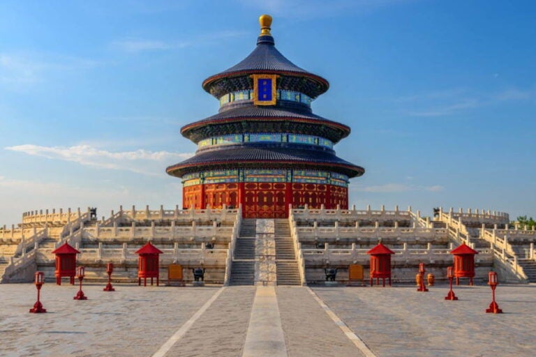 北京・天壇公園の祈年殿を正面から捉えた荘厳な佇まいと赤い灯籠が並ぶ参道