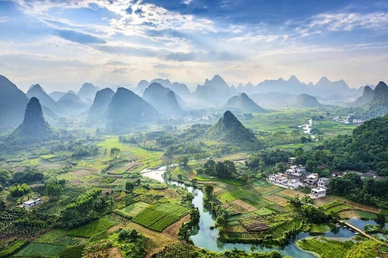 桂林のカルスト地形の山々と田園風景の間を蛇行する川を上空から捉えた絶景