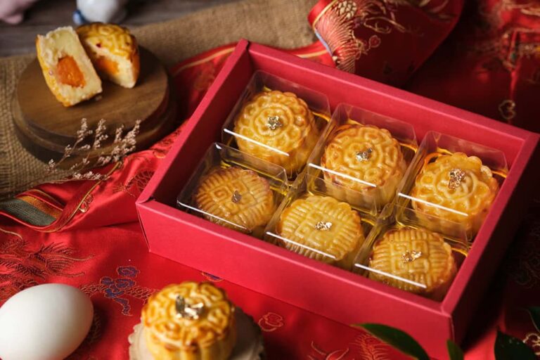 赤い化粧箱に個包装で並ぶ中国伝統の月餅と断面から見える餡