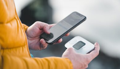 スマートフォンとモバイルWi-Fiルーターを手に持つ旅行者