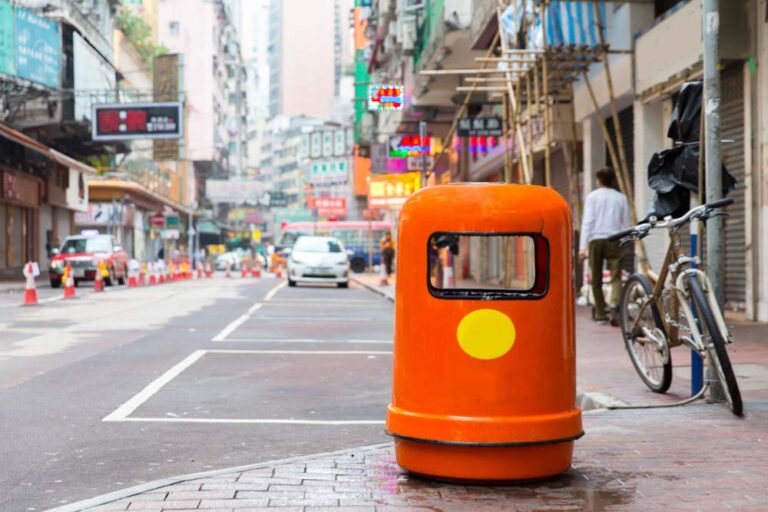 香港・佐敦の街角に置かれたオレンジ色のゴミ箱と下町の通り