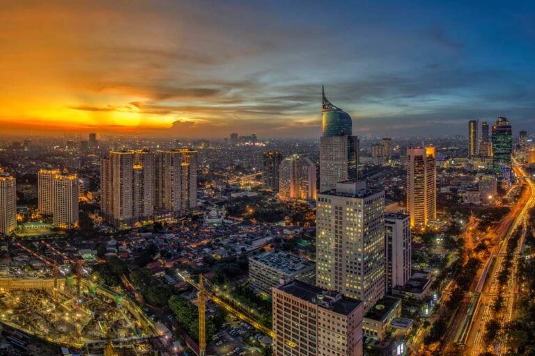 夕焼けに染まるジャカルタの高層ビル群と都市の夜景