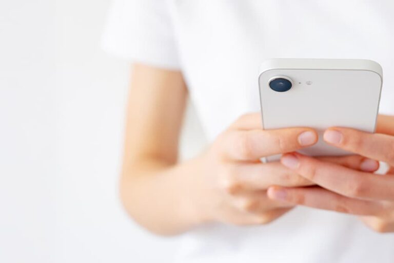 空港でiPhoneのPDP認証エラーに困惑する女性旅行者のイメージ