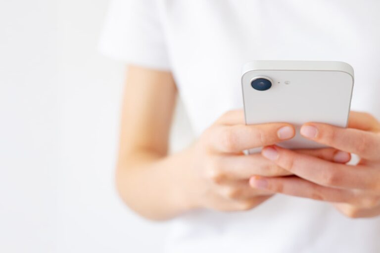 PDP認証エラーの対処のためiPhoneを手に持つ人物のイメージ