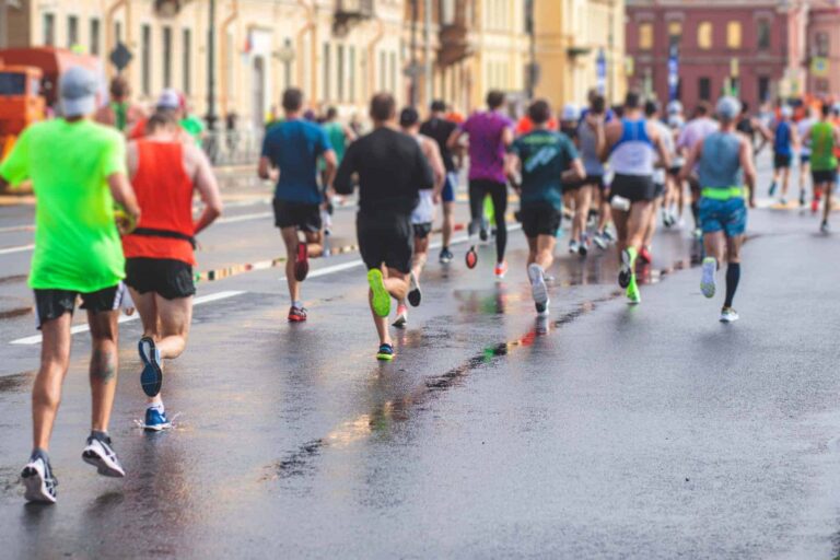 ：雨に濡れた市街地の道路を大勢のランナーが走るロンドンマラソンのイメージ